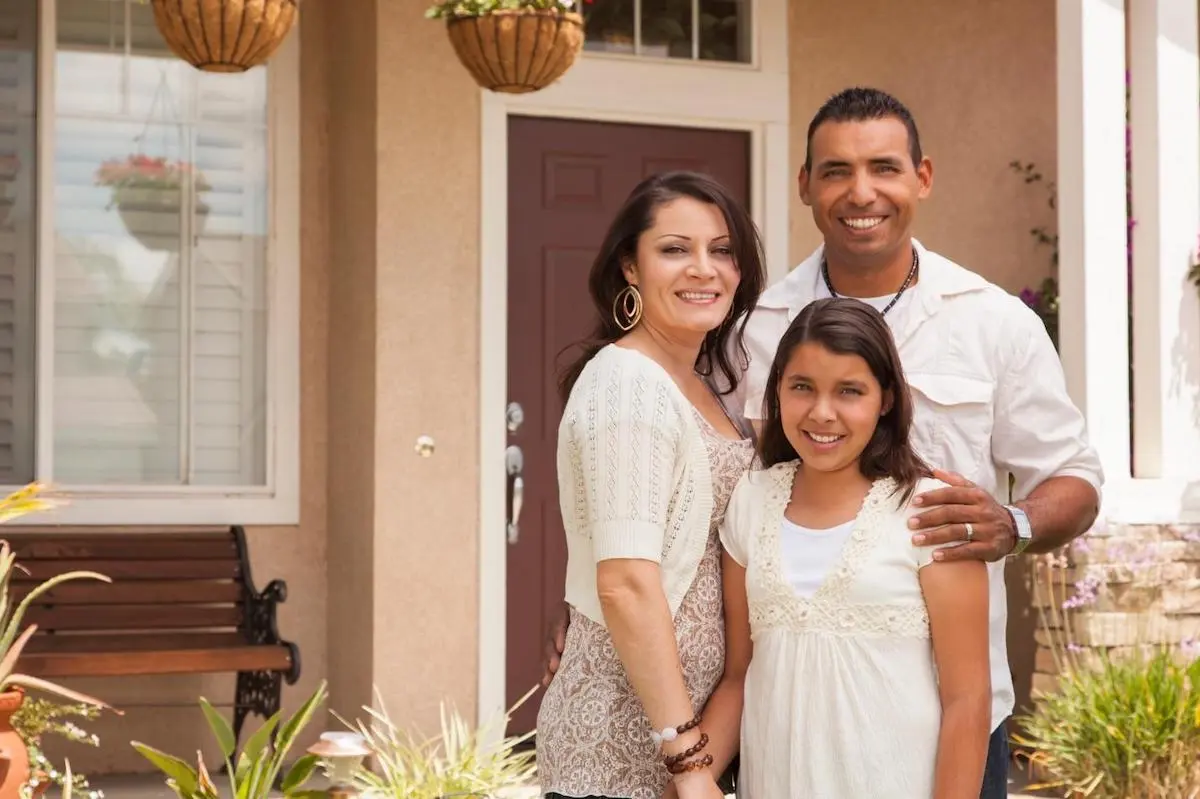 immigrant family in front of their new home